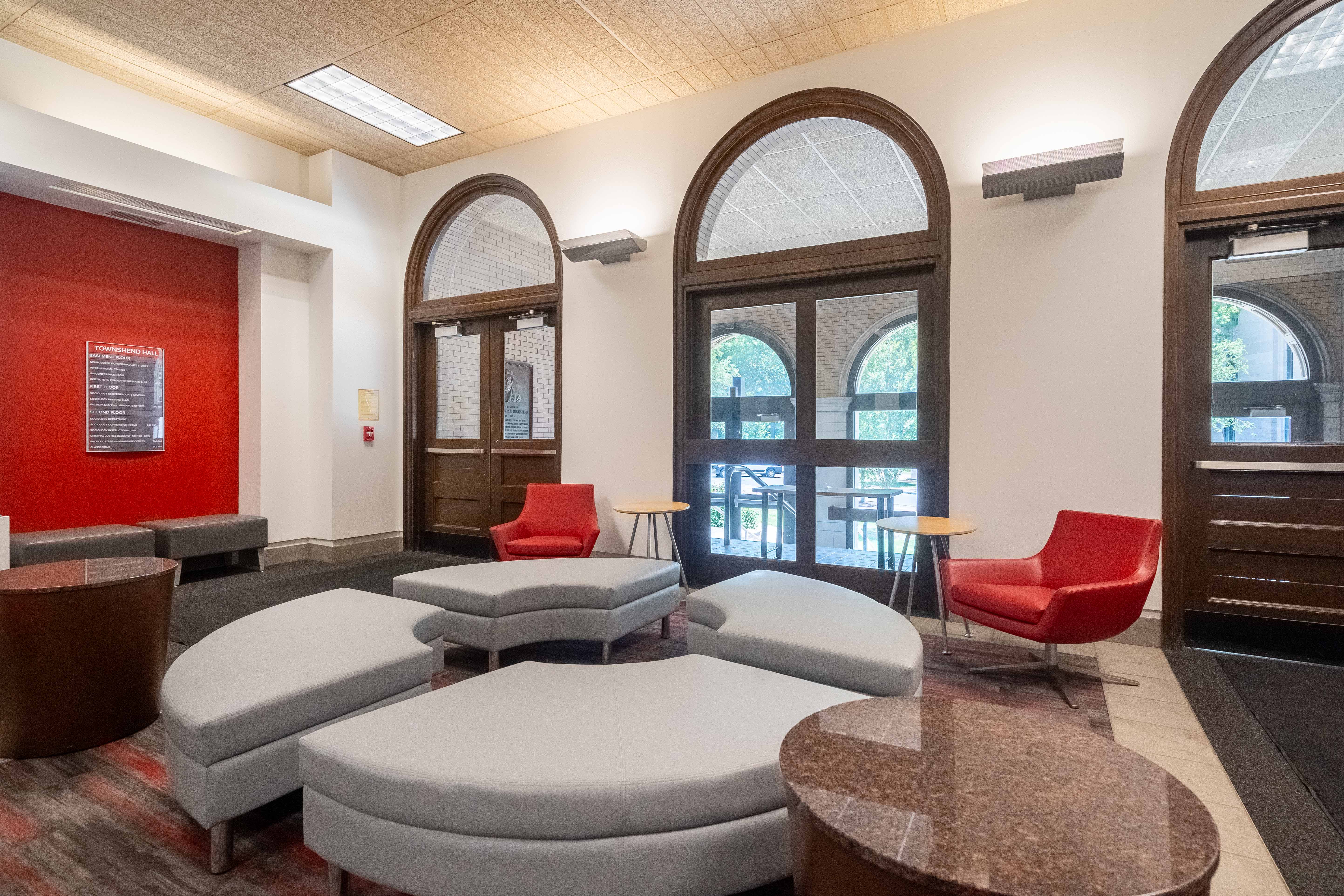 lobby with large windows and soft, moveable furniture.