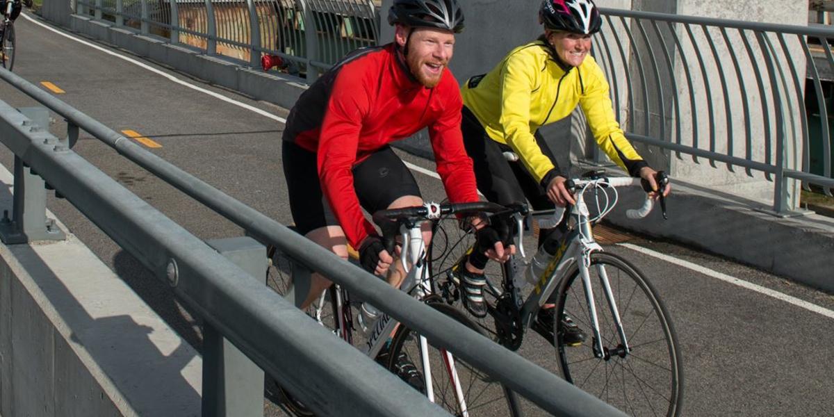 two cyclists on bikes with helmets