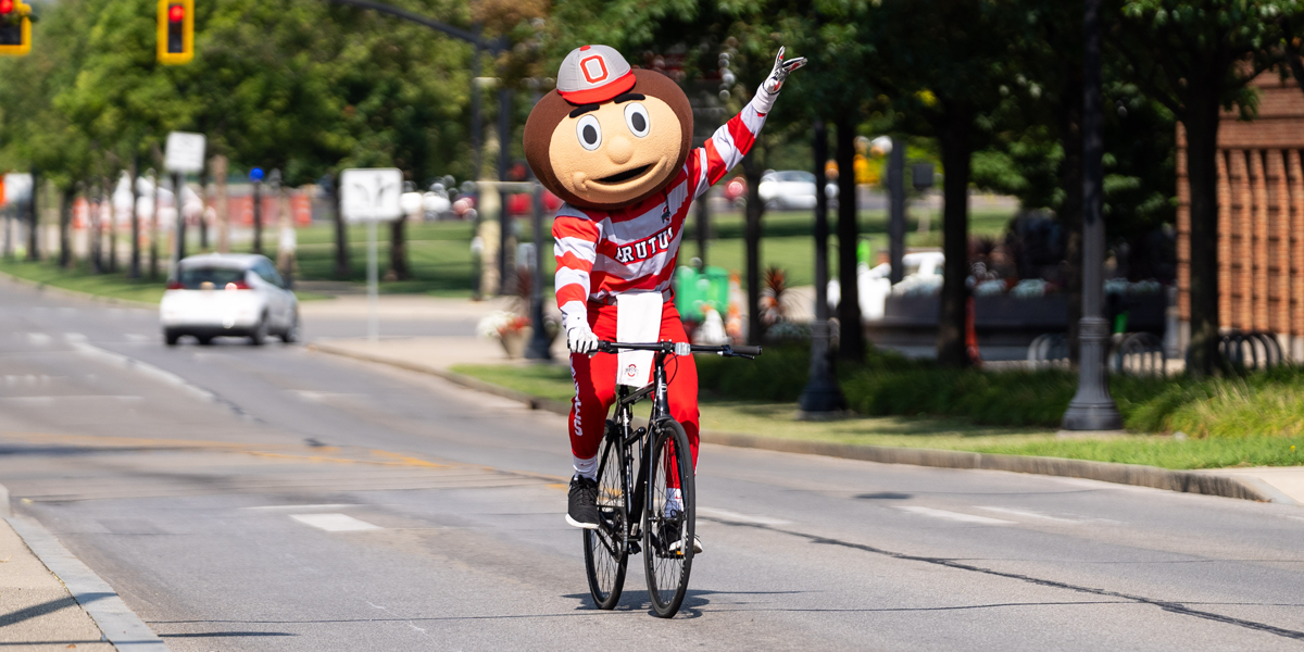 Brutus Buckeye riding on a bike