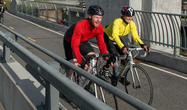 two cyclists on bikes with helmets