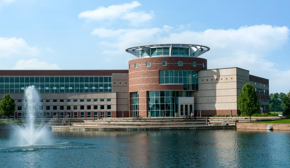 The Ohio State University Marion campus building sitting on edge of a pond with a water fountain