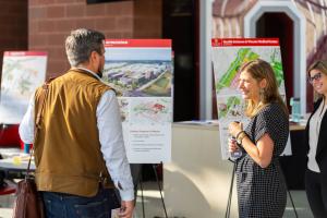 Two people are seen smiling while talking in front of a Framework 3.0 signboard that reads "Carmenton"